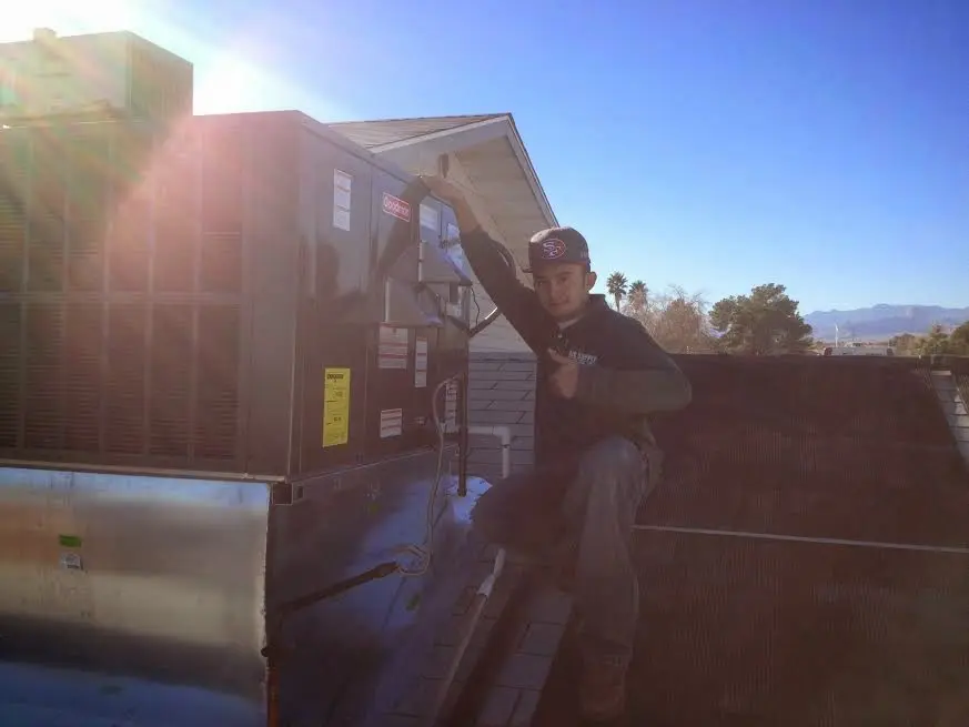 HVAC technician performing Boiler Repair on a rooftop unit in Mount Laurel